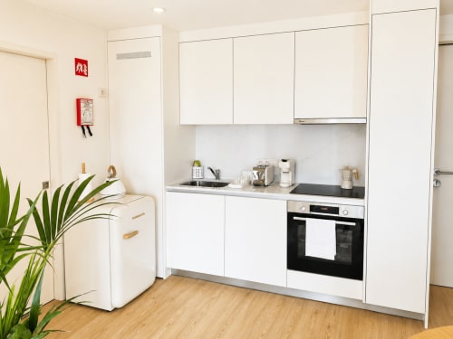Cozinha branca e moderna com eletrodomésticos compactos no Apartamento Lumina, Terra Clara Studios, Esposende