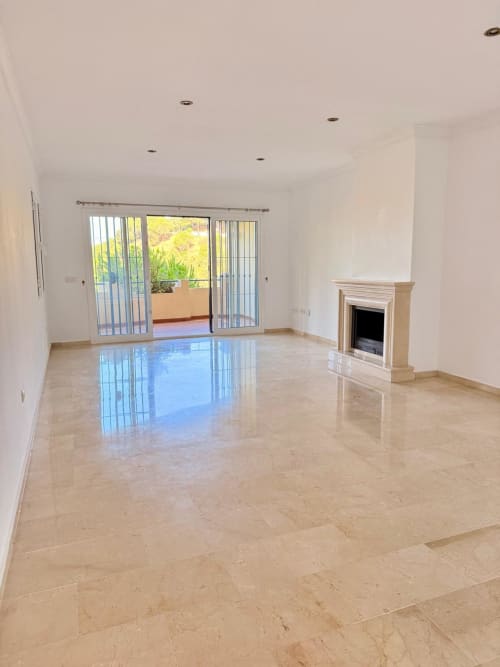 Amplio salón de mármol con chimenea y acceso a terraza en el hotel BH Marbella