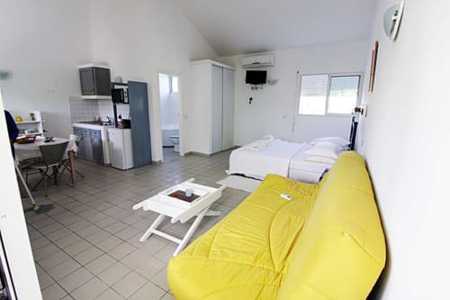 Grand bungalow à Balaga Vacances, Sainte-Anne avec pouf jaune, lits, kitchenette et climatisation