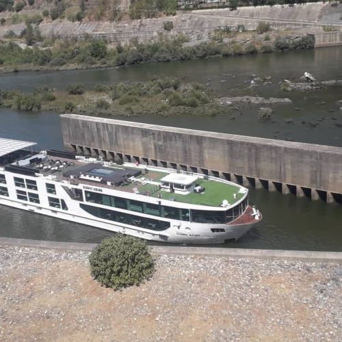 Navio de cruzeiro Scenic Azure no rio Douro perto de Folgosa, Portugal com barragem e vinhedos nas encostas