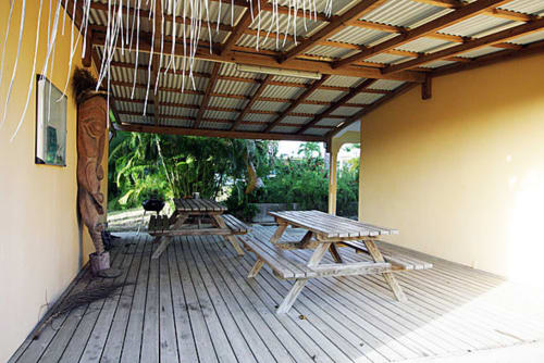 Terrasse couverte avec tables de pique-nique au gîte Balaga Vacances à Sainte-Anne, Guadeloupe, surplombant des jardins tropicaux