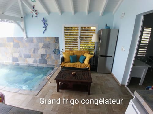 Loft Mer aux Colibris Amoureux : piscine chauffée, canapé jaune, réfrigérateur inox et vue sur mer à Grand Bourg