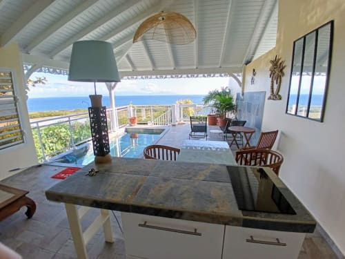 Cuisine moderne avec vue sur la mer donnant sur le lagon à Aux Colibris Amoureux B&B à Grand Bourg