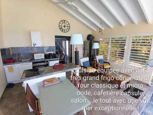 Cuisine équipée et séjour avec vue sur mer au loft Aux Colibris Amoureux à Grand Bourg