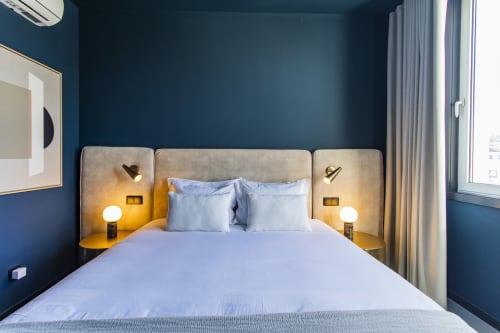 Studio Classic bedroom at Benefit Collection Porto with blue walls, beige headboard, garden view through curtains