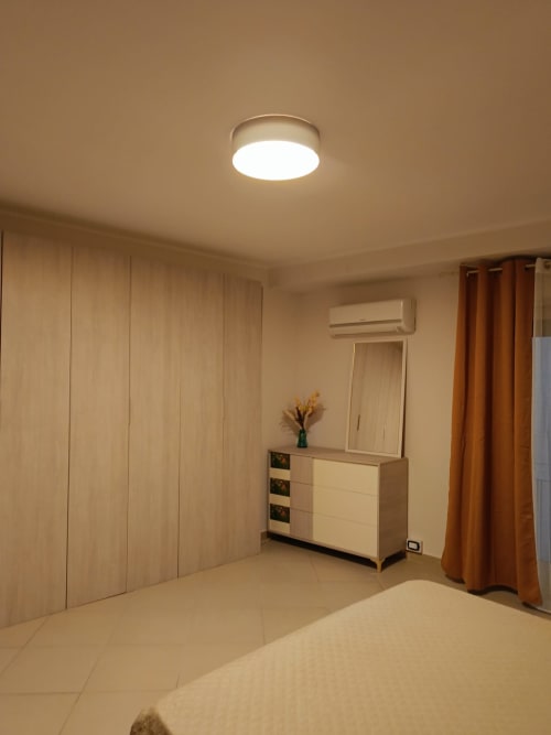 Camera moderna a Domus Smartrooms di Sellia con letto matrimoniale, armadio in legno, comò con specchio e illuminazione LED al soffitto