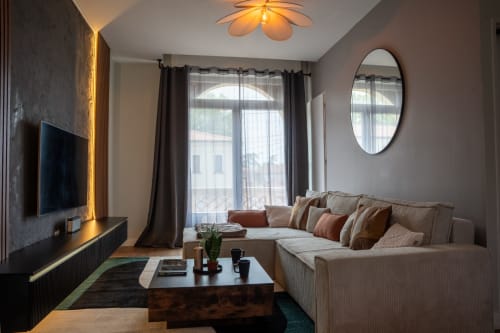 Salon Loft Prestige au 1 Péraudel à Castres : canapé crème, écran plat, vue sur la ville
