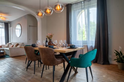 Coin repas Loft Prestige au Le 1 Péraudel Suite & Appts à Castres avec table en bois, chaises design, luminaires suspendus et vue citadine