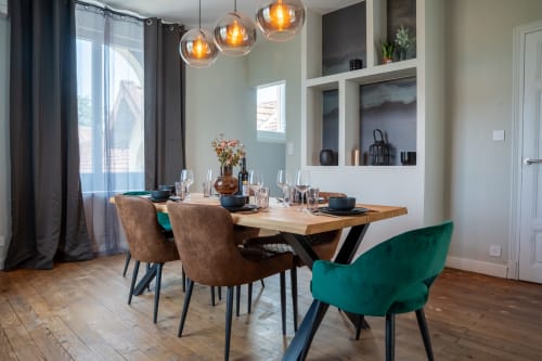 Salle à manger contemporaine du loft Prestige à Le 1 Péraudel, Castres : table en bois, chaises turquoise et marron, luminaire suspendu