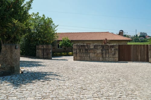 Entrada de pedra da Quinta de Carvalhal com arquitetura portuguesa tradicional, pátio em calçada e portão de madeira