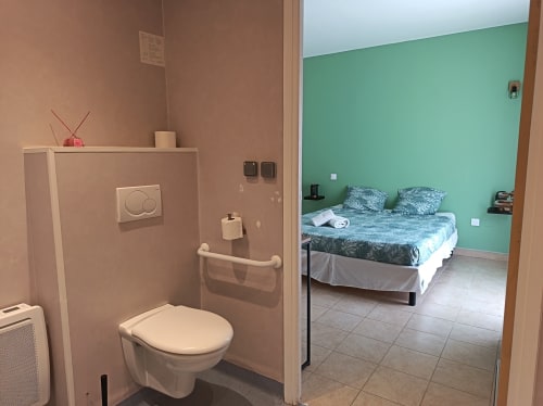 Chambre PMR accessible au Clos du Thoronet avec salle de bain attenante, lit double à tête de lit verte