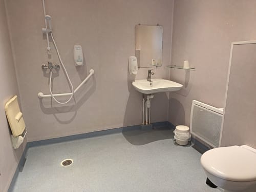 Salle de bains accessible de l'hôtel Le Clos du Thoronet avec lavabo accessible, barres d'appui et espace dégagé