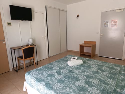 Chambre PMR accessible au Clos du Thoronet avec TV, bureau, lit et mobilier en bois