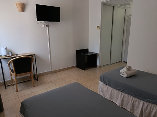Chambre twin de l'hôtel Le Clos du Thoronet avec TV, bureau et équipements modernes au Thoronet, France