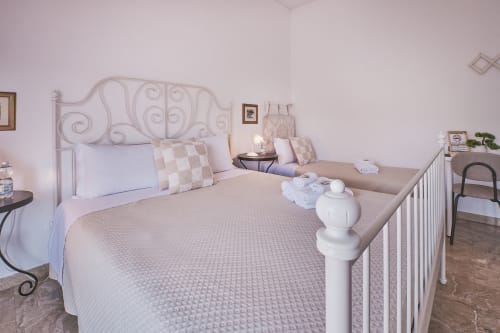 Tripla a Casa Mia B&B Italia con testata in ferro battuto ornamentale, biancheria bianca e letto singolo