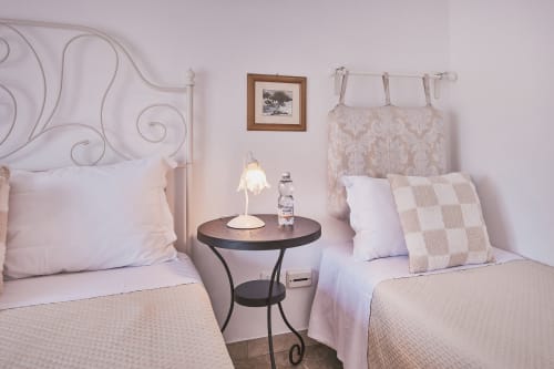 Luminosa camera tripla a Casa Mia B&B con due letti, testiere in ferro e elegante decoro damasco in Italia