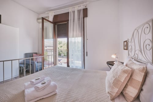 Camera luminosa con letto matrimoniale, accesso al balcone e vista sulla campagna italiana