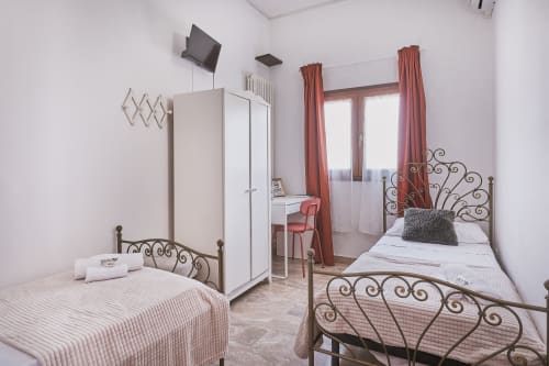 Camera doppia con due letti singoli presso Casa Mia B&B in Italia, con letti in ferro battuto e finestre con vista sulla città