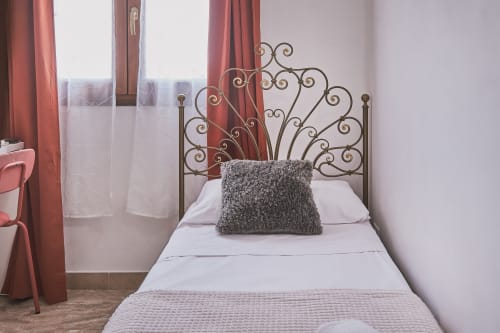 Accogliente camera matrimoniale a budget presso Casa Mia B&B in Italia con letto in ferro battuto ornamentale e vista sulla città