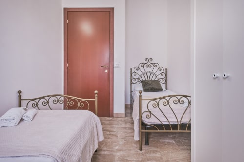 Camera doppia con due letti singoli presso Casa Mia B&B in Italia, con eleganti strutture in ferro battuto e vista sulla città