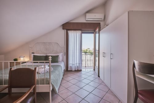 Camera luminosa in soffitta di Casa Mia B&B con balcone, aria condizionata e vista città in Italia