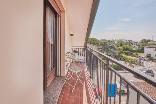 Balcone soleggiato con sedia decorativa che affaccia sulla cittadina italiana di provincia presso Casa Mia B&B