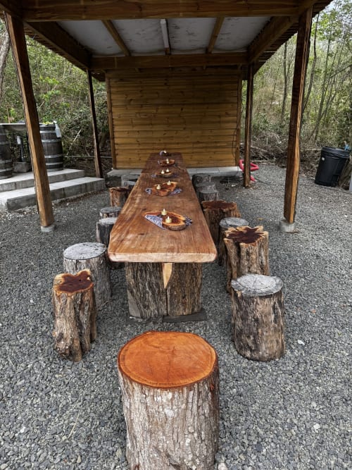 Table de rassemblement rustique en bois avec sièges en rondins sous pavillon couvert à Jo'z Le Rêve, Martinique