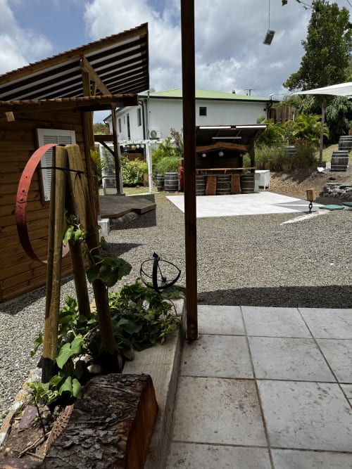 Réception de Jo'z Le Rêve aux Anses d'Arlet avec pergolas en bois, cour gravillonnée et vue sur les montagnes