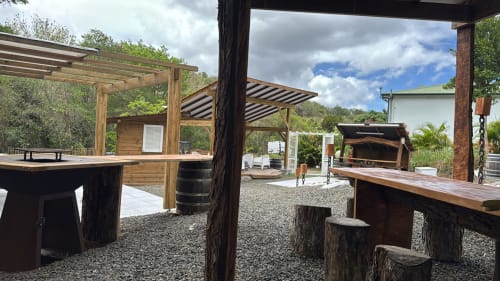 Espace de réception extérieur à Jo'z Le Rêve aux Anses d'Arlet avec pergolas en bois, bar et vue sur les montagnes