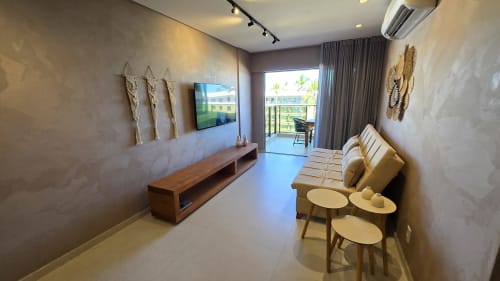 Sala de estar moderna em Labedi Apartamentos, Maceió com TV, área de estar e vista da varanda