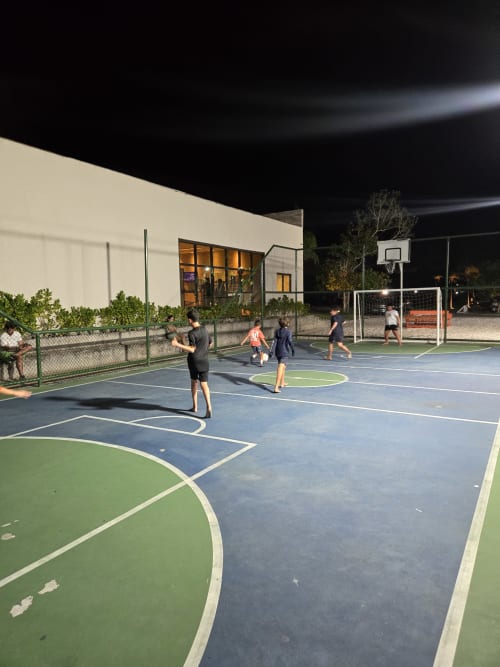 Hóspedes jogando basquete e futebol em quadras iluminadas do boutique Labedi Apartamentos em Maceió, Brasil
