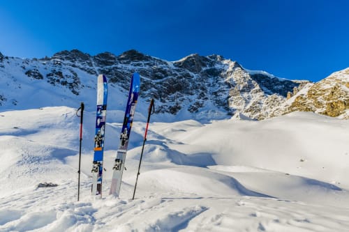 Sci e bastoncini piantati nella neve con le Alpi sullo sfondo vicino a Le Alpi bed&living, Cividate Camuno