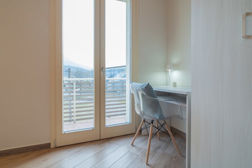 Camera moderna del Le Alpi B&B a Cividate Camuno con balcone, vista montagne, scrivania e sedia