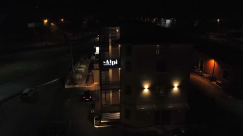 Ingresso illuminato della struttura Le Alpi bed & living, Cividate Camuno Italia, con architettura moderna di notte