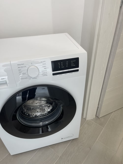 Lavatrice con carica frontale bianca e display digitale nel bagno di Rigiariloo Home Apartments, Termoli Italia