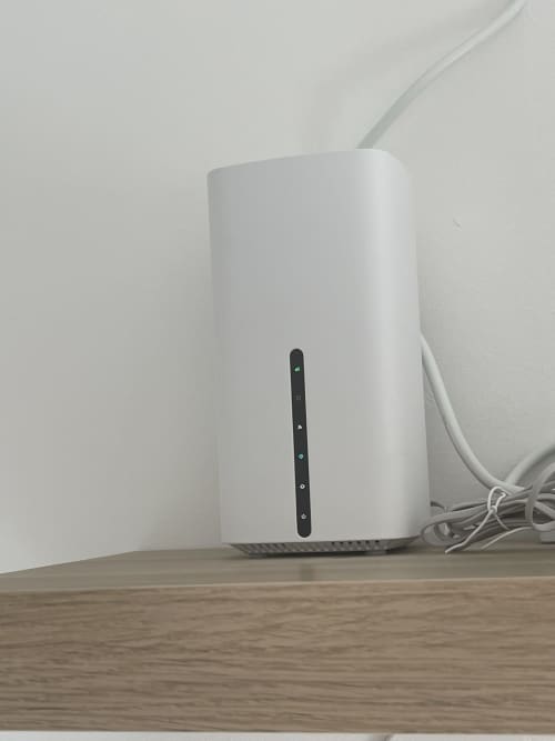 Router WiFi bianco con indicatori LED su tavolo in legno negli Appartamenti Rigiariloo Home, Termoli