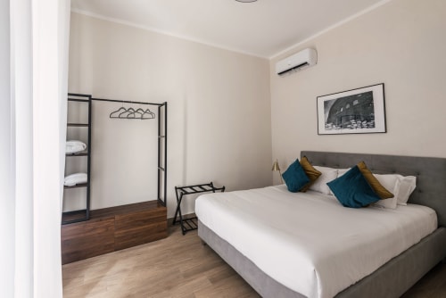 Camera moderna nella Casa Vacanze di Flavia a Roma con letto matrimoniale, cuscini turchesi e arredamento minimalista