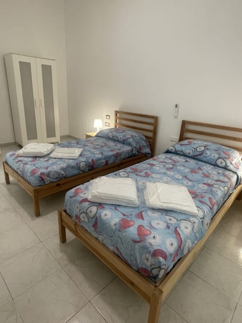 Due letti gemelli con biancheria blu decorata e lenzuola bianche nell'appartamento Nautilus di Rigiariloo Home Apartments, Termoli