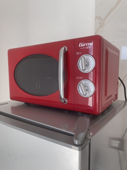 Forno a microonde Girmi rosso vintage sul bancone dell'appartamento Rigiariloo Home Apartments a Termoli