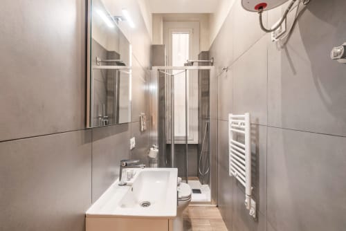 Bagno moderno nella Holiday Home Roma di Flavia con lavabo bianco, box doccia in vetro e scaldasalviette