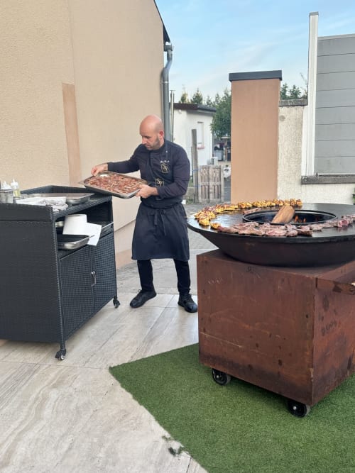 Chef grilling meat at Hôtel-Restaurant le S'Y in Seingbouse, outdoor patio with firepit