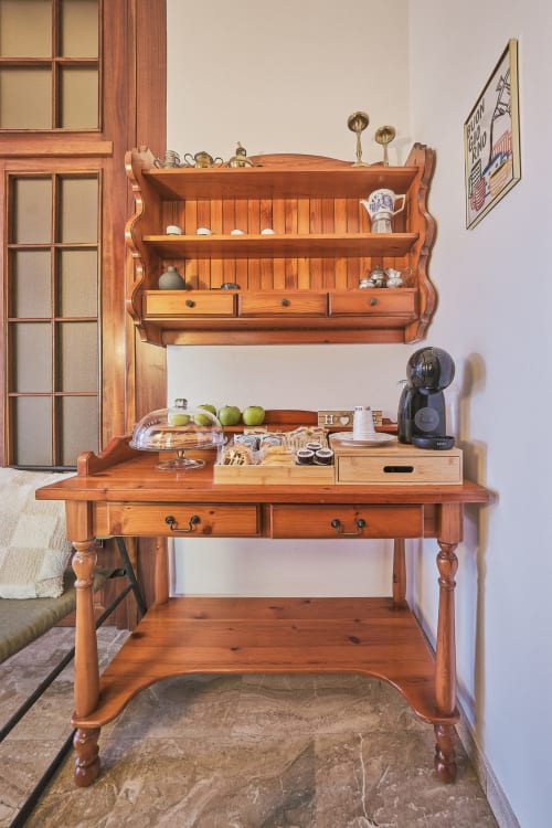 Spazio di lavoro in legno con mensola e macchina da caffè a Casa Mia B&B, Porto Viro. Scrivania vintage con mele e decorazioni.