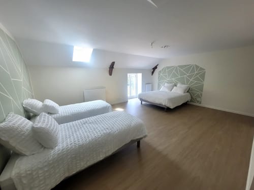 Chambre spacieuse aux Chambres d'hôtes Le Clos de la Touche à Cheillé avec deux lits et décoration murale géométrique