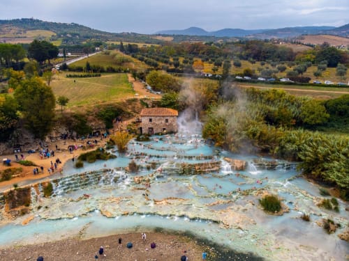Vista aerea delle terme di Saturnia con casale in terracotta, vasche termali e paesaggio toscano vicino a Canino, Italia