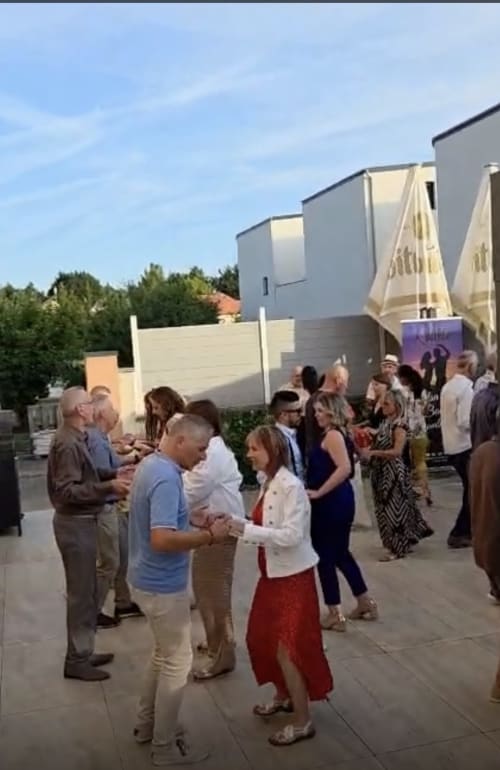 Outdoor gathering at Hôtel-Restaurant le S'Y in Seingbouse with guests enjoying a reception on the terrace.