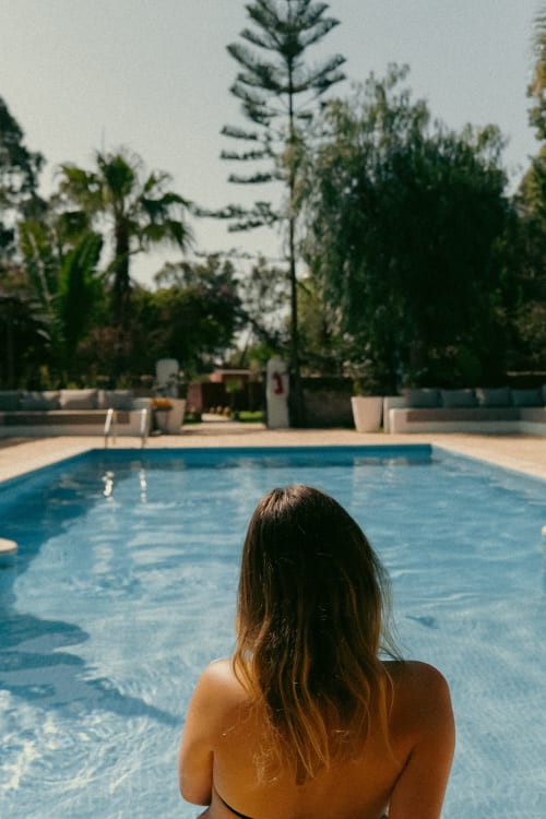 Femme détente dans la piscine chauffée de l'hôtel Eucalyptus Ethnic à Essaouira, avec palmiers et spa