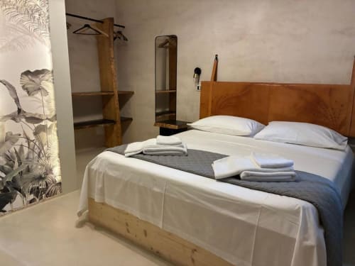 Camera da letto moderna a Casa Città B&B a Brescia con testiera in legno, biancheria bianca, scaffali e arte botanica alle pareti