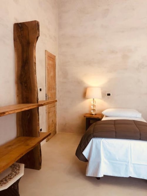 Camera Tripla Deluxe a Casa Città Brescia con mobili in legno, letto con biancheria bianca, lampada comodino e vista sulla corte interna