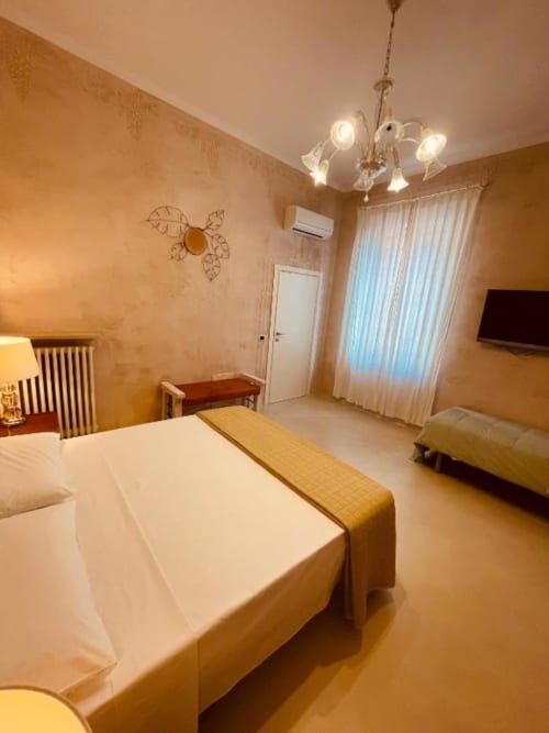 Deluxe Triple Room a Casa Città, Brescia - camera spaziosa con letto matrimoniale, arredi dorati, lampadario moderno e TV