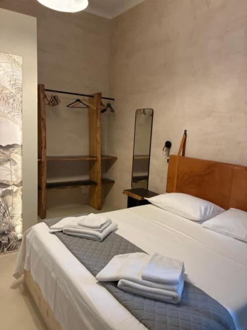 Camera matrimoniale luminosa a Casa Città B&B Brescia con letti gemelli, attaccapanni in legno, specchio e arredamento minimalista